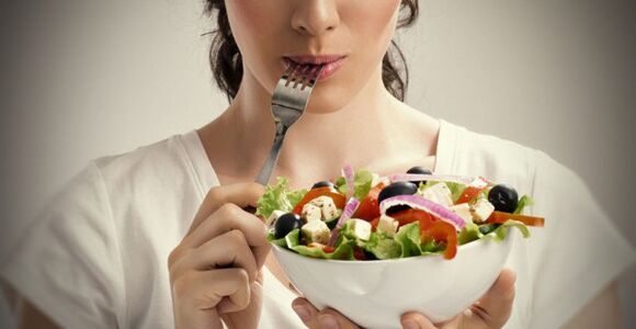 Tüdruk hoiab taldrikut salatit